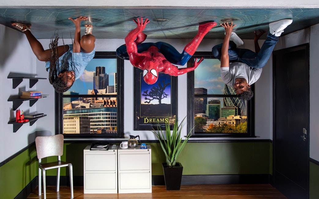 Spiderman figure with visitors on ceiling at Madame Tussauds London.