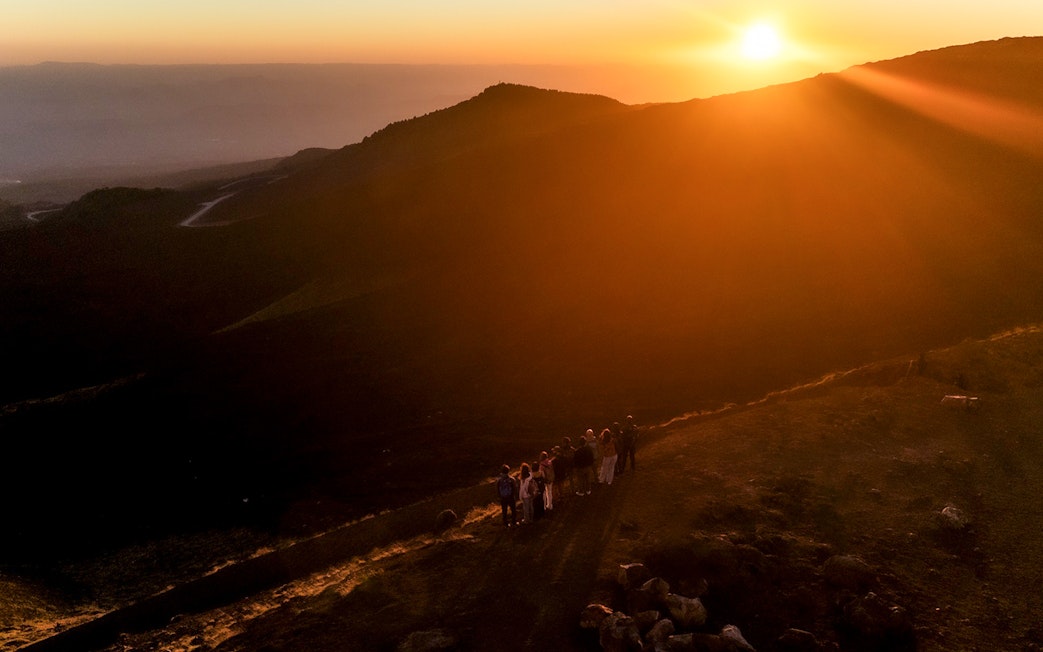 Group of people watching sunset on Mount Etna, Sicily.