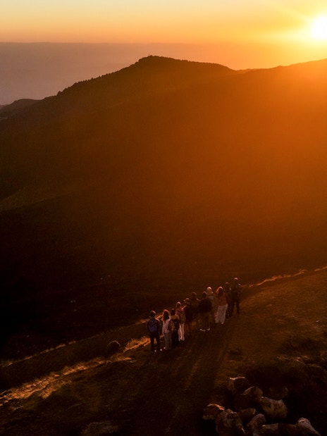 Group of people watching sunset on Mount Etna, Sicily.