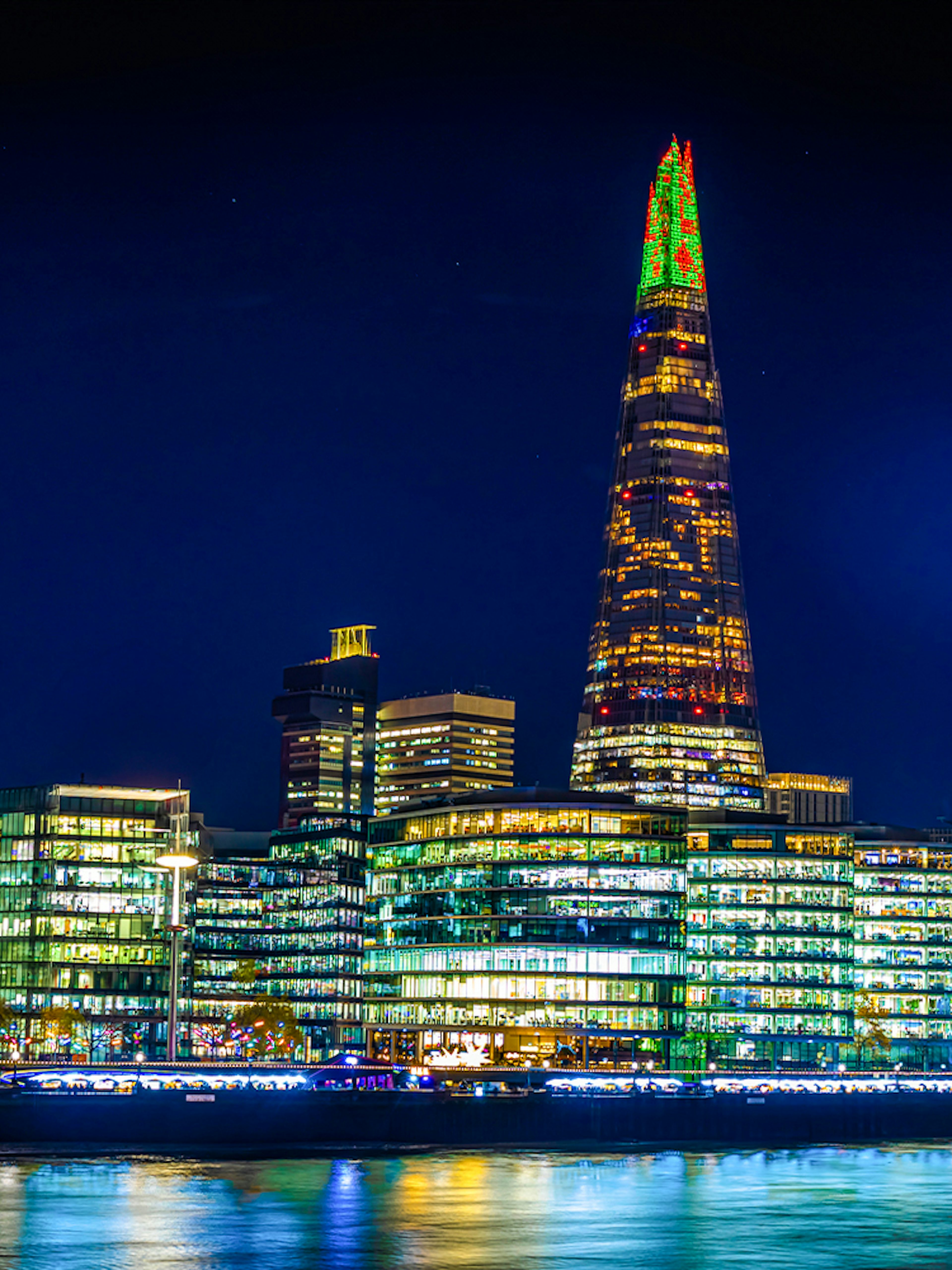 Christmas lights illuminate The Shard in London at night.