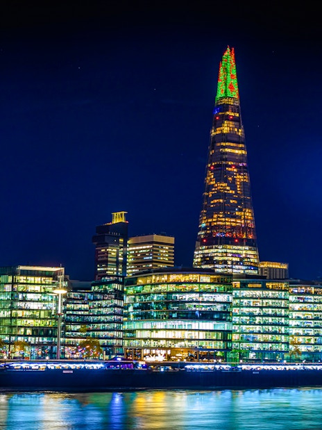 Christmas lights illuminate The Shard in London at night.