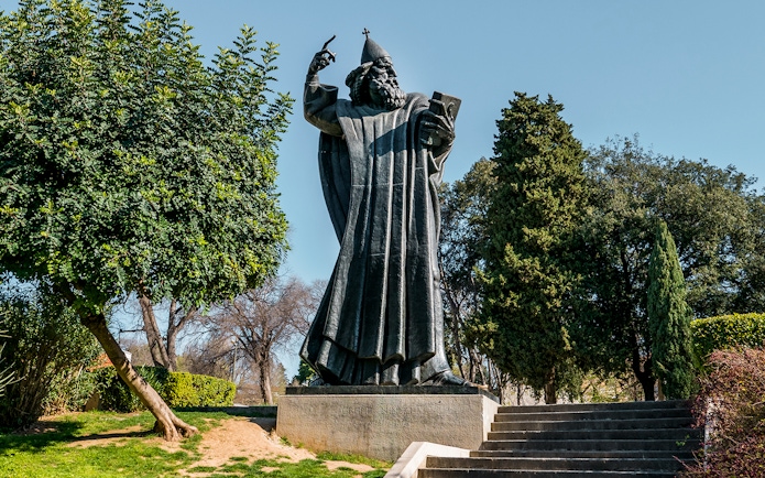 Statue of Grgur Ninski in Split, Croatia, surrounded by trees.