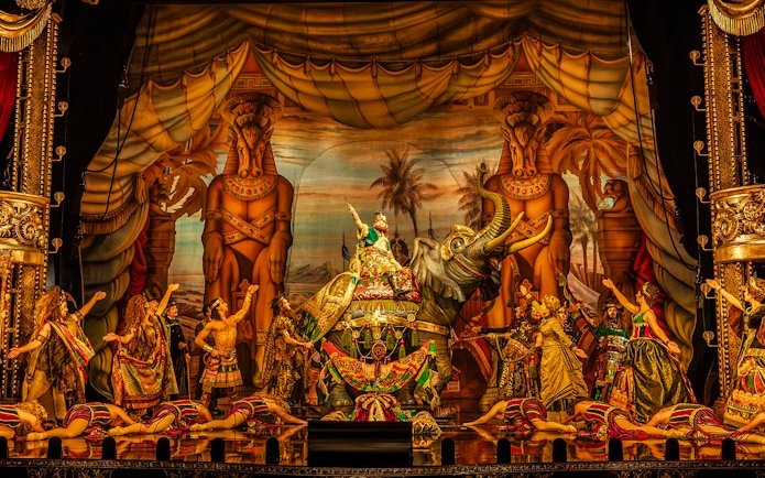 Phantom of the Opera stage scene with performers in elaborate costumes and an elephant prop.