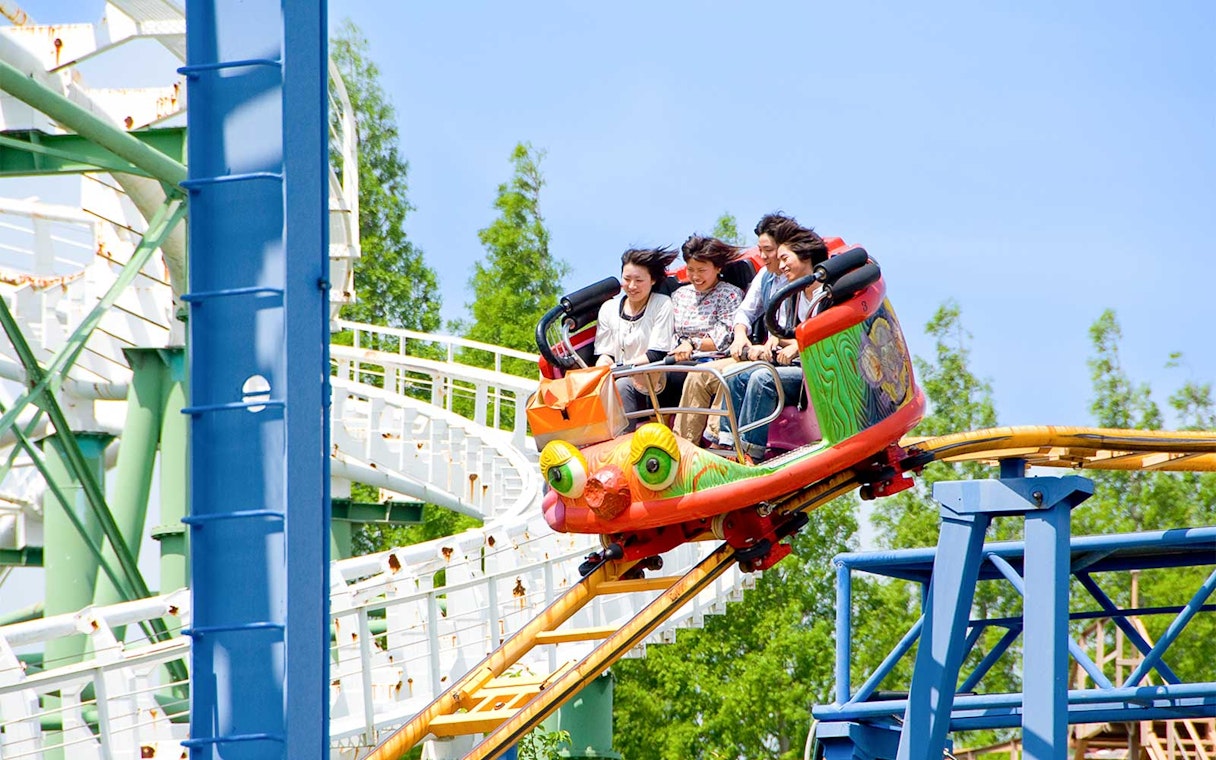 Roller coaster ride at Hirakata Park with passengers enjoying the thrill.