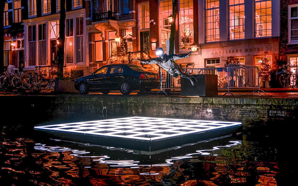 Sculpture and illuminated platform on Amsterdam canal during Light Festival cruise.