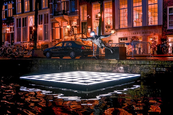 Sculpture and illuminated platform on Amsterdam canal during Light Festival cruise.