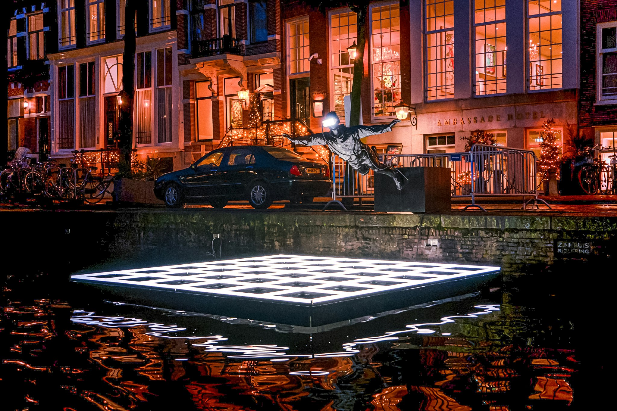 Sculpture and illuminated platform on Amsterdam canal during Light Festival cruise.