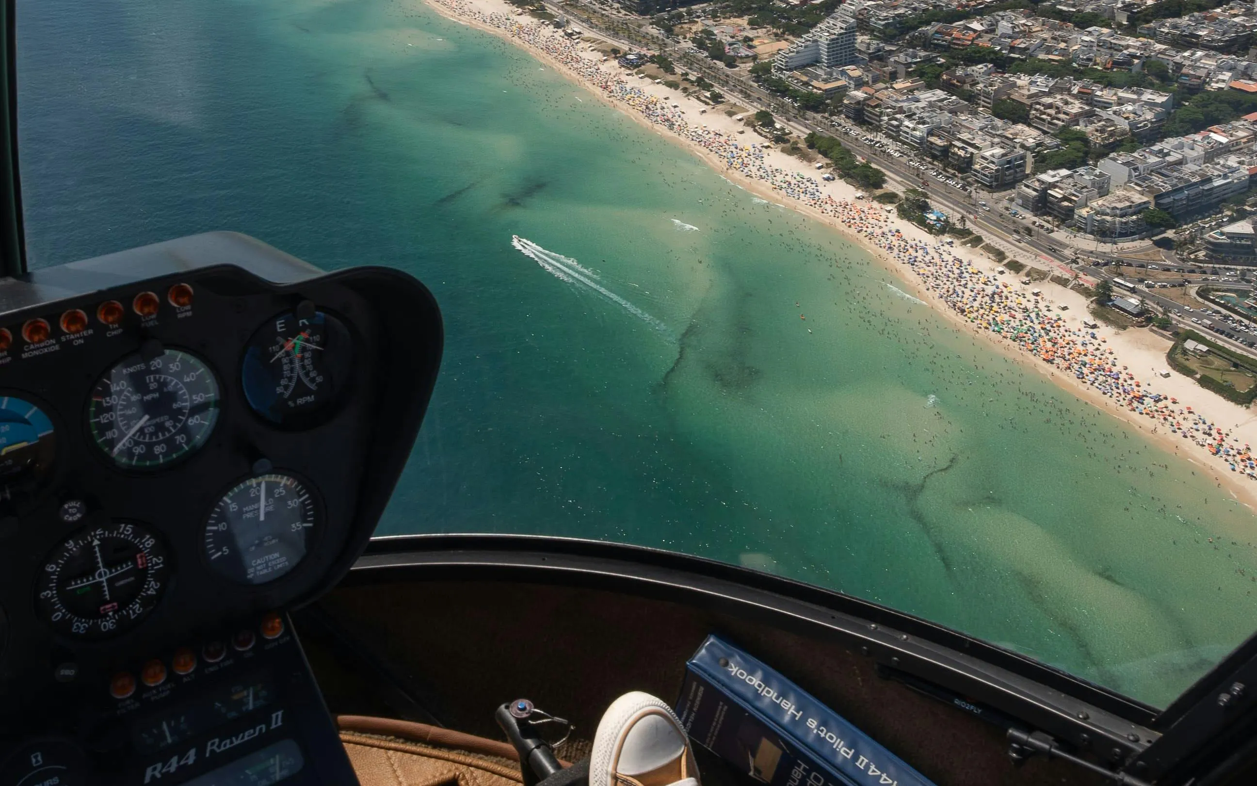 Cockpit view of helicopter tour over Rio de Janeiro coastline and beaches.