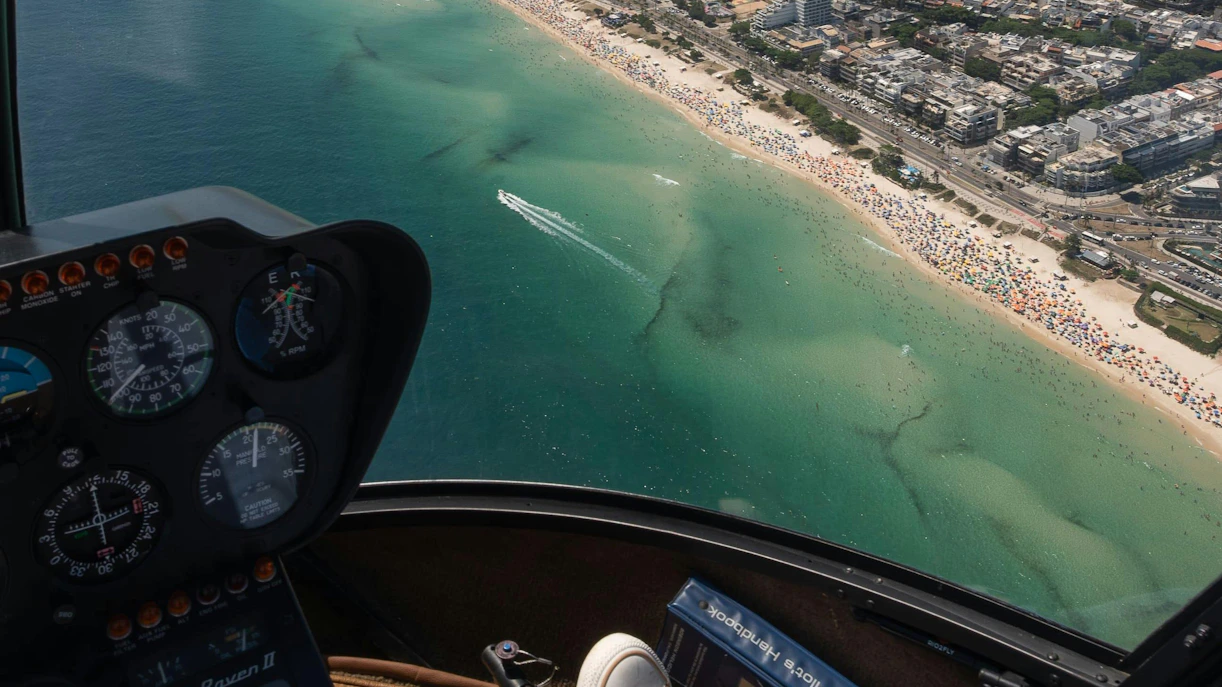 Cockpit view of helicopter tour over Rio de Janeiro coastline and beaches.