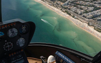 Cockpit view of helicopter tour over Rio de Janeiro coastline and beaches.