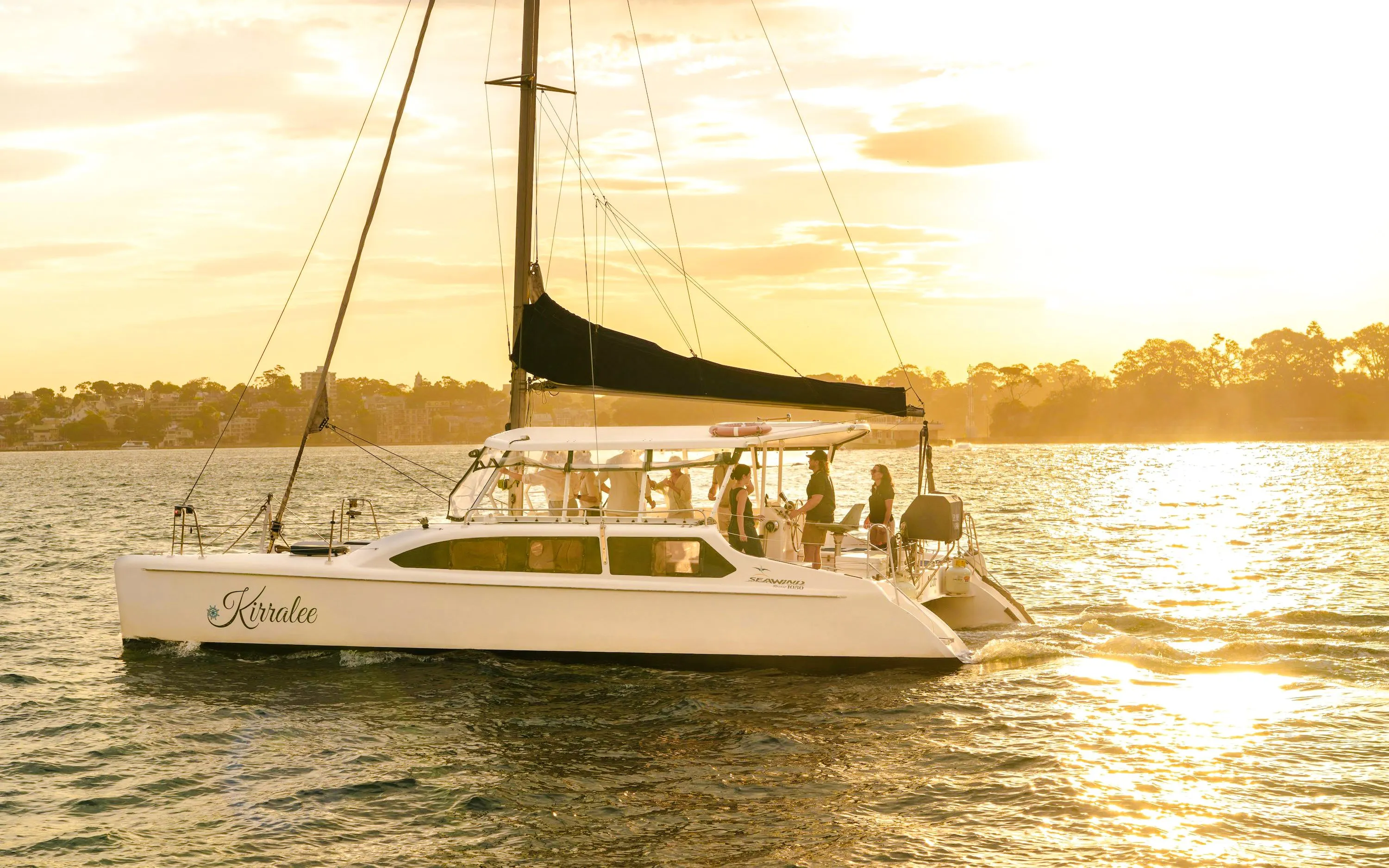 Guests enjoying a Sydney Harbour cruise at sunset on a sailboat.