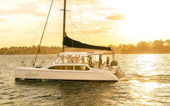 Guests enjoying a Sydney Harbour cruise at sunset on a sailboat.