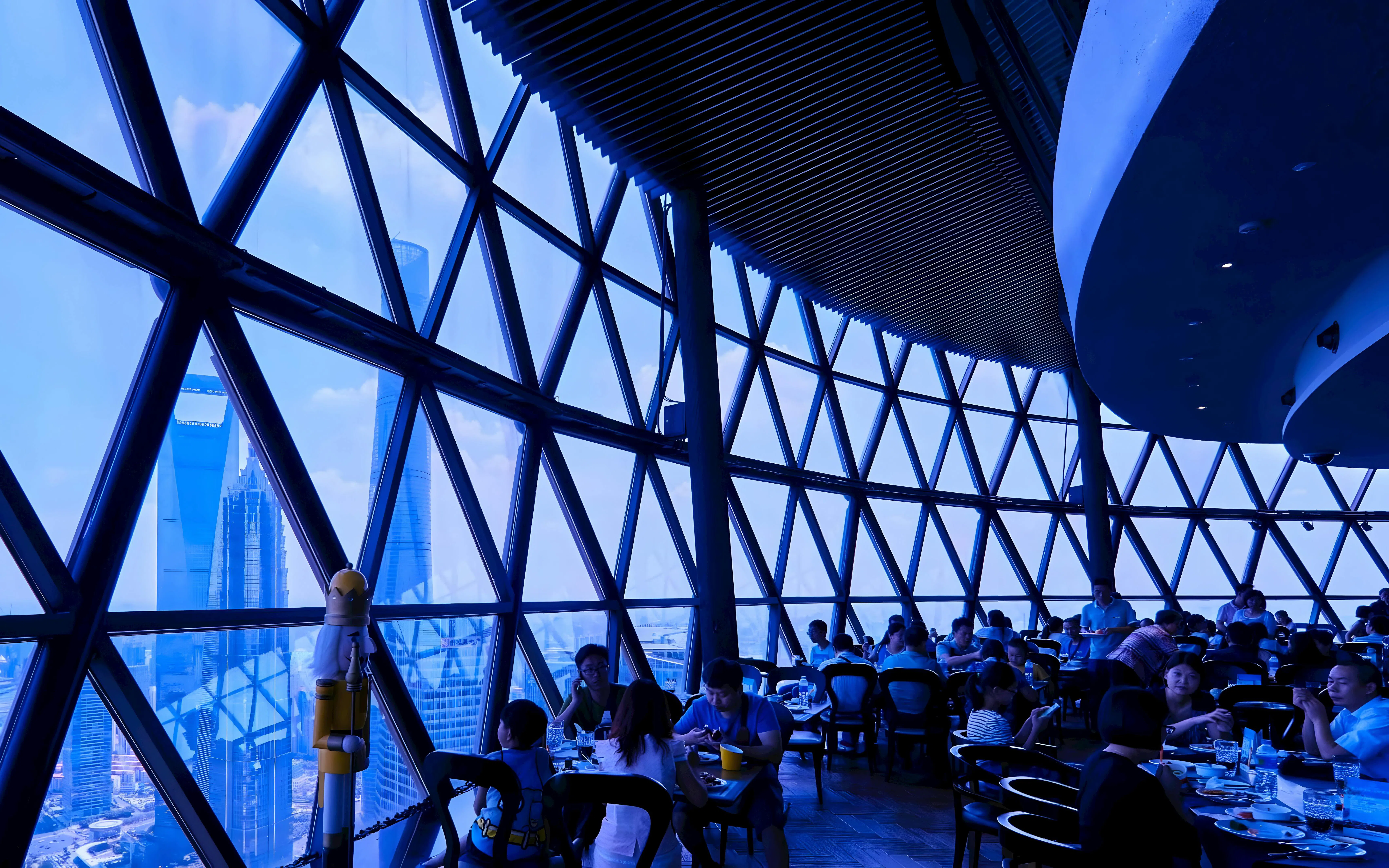 Dining experience at revolving restaurant, Oriental Pearl Tower, Shanghai with city skyline views.