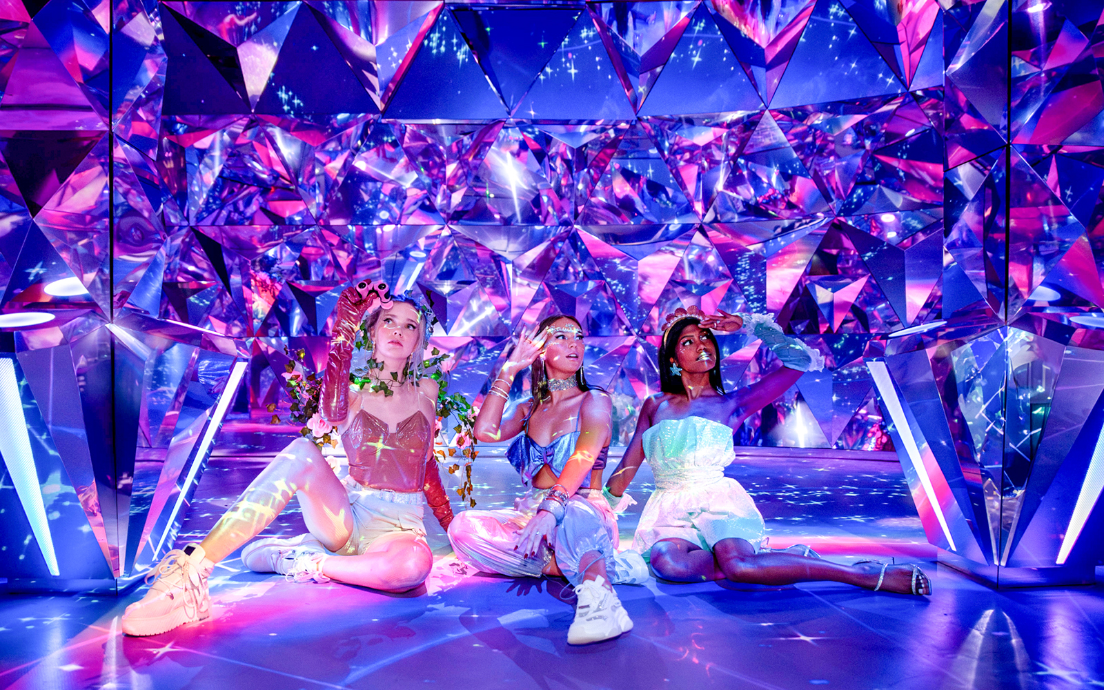 Visitors enjoying the colorful, reflective room at WONDR Experience.