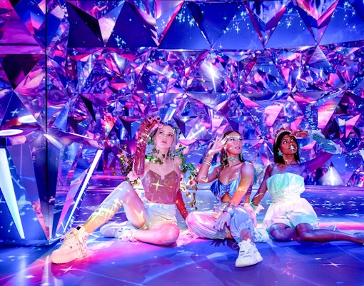 Visitors enjoying the colorful, reflective room at WONDR Experience.