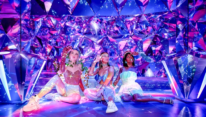 Visitors enjoying the colorful, reflective room at WONDR Experience.