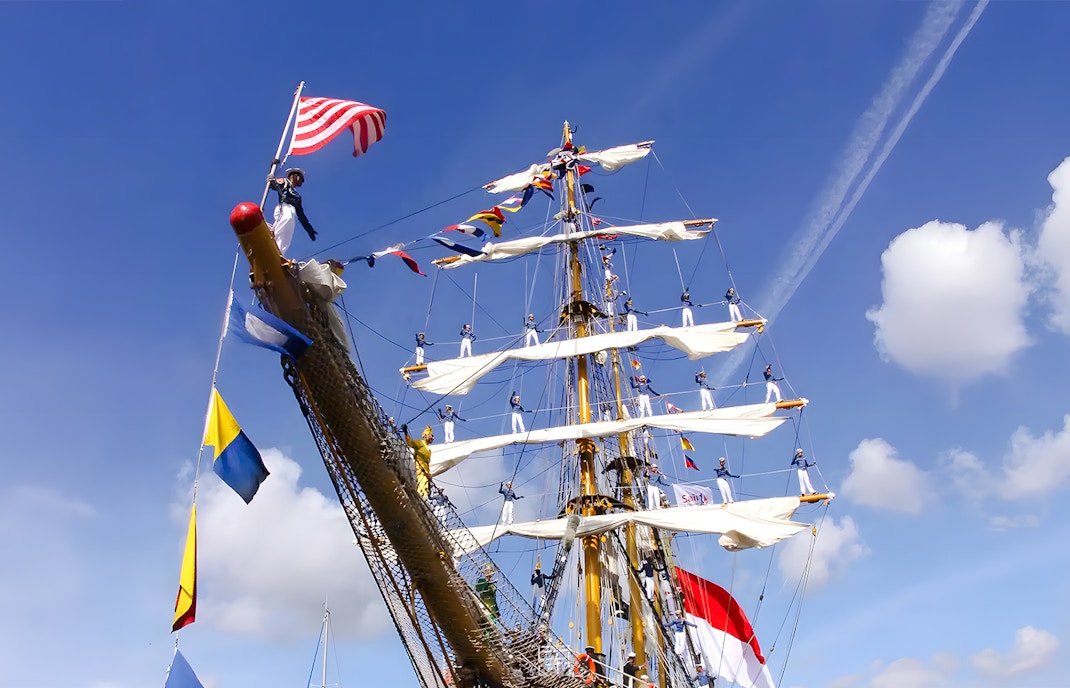 Tall ship with sailors on masts during Sail Amsterdam event.