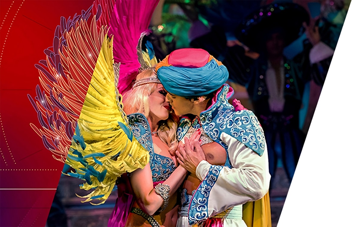 Performers in vibrant costumes embrace during Moulin Rouge Valentine's Day show.