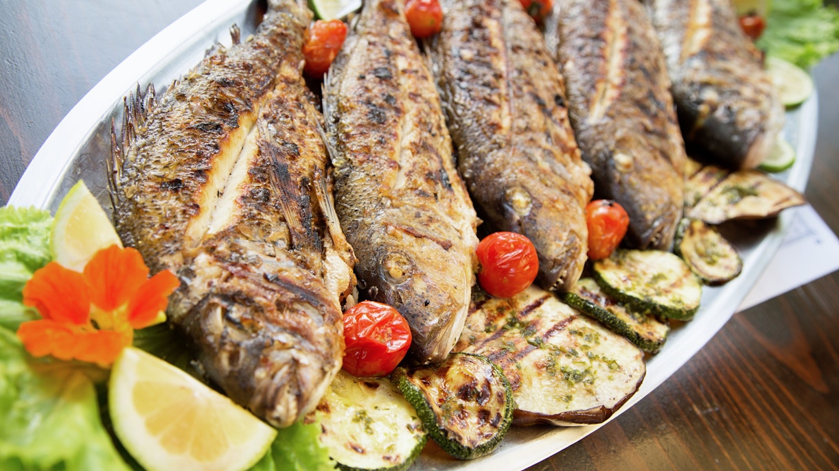 Grilled fish with vegetables in a konoba, Dalmatia, Croatia.
