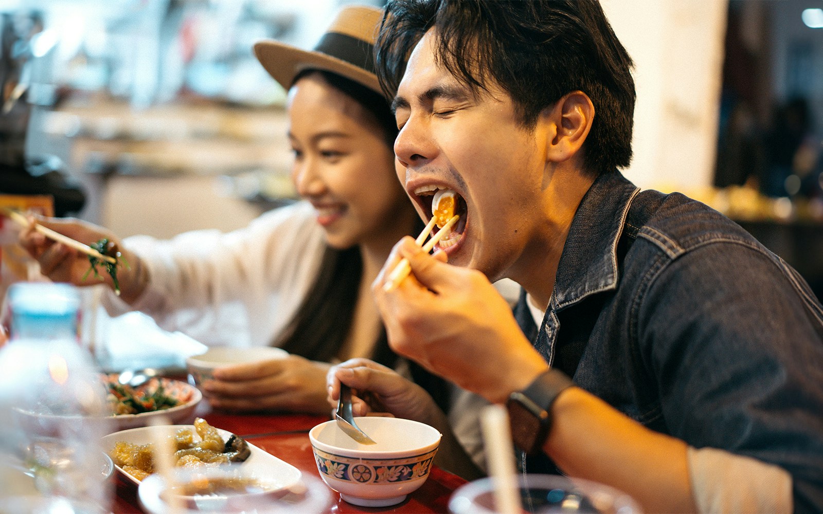Tourists enjoying Thai cuisine at a vibrant outdoor restaurant in Siam Park, Thailand.