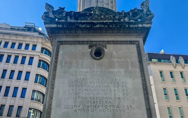 Inscriptions on the Monument to the Great Fire of London, detailing historical figures and dates.