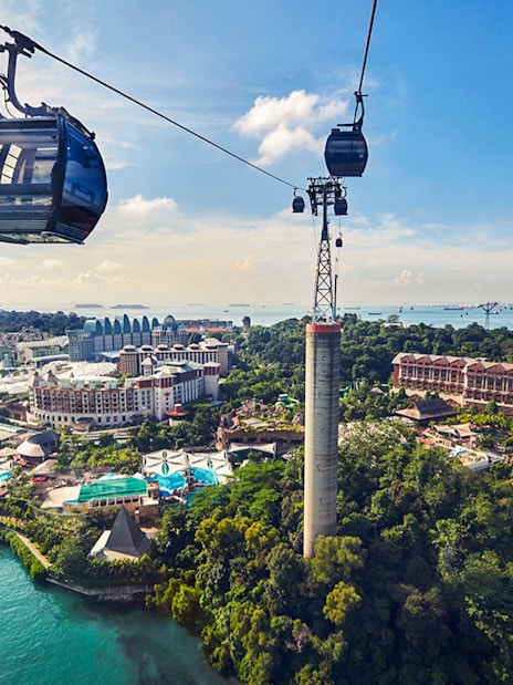 Cable car over Sentosa Island, Singapore, with view of attractions and coastline.