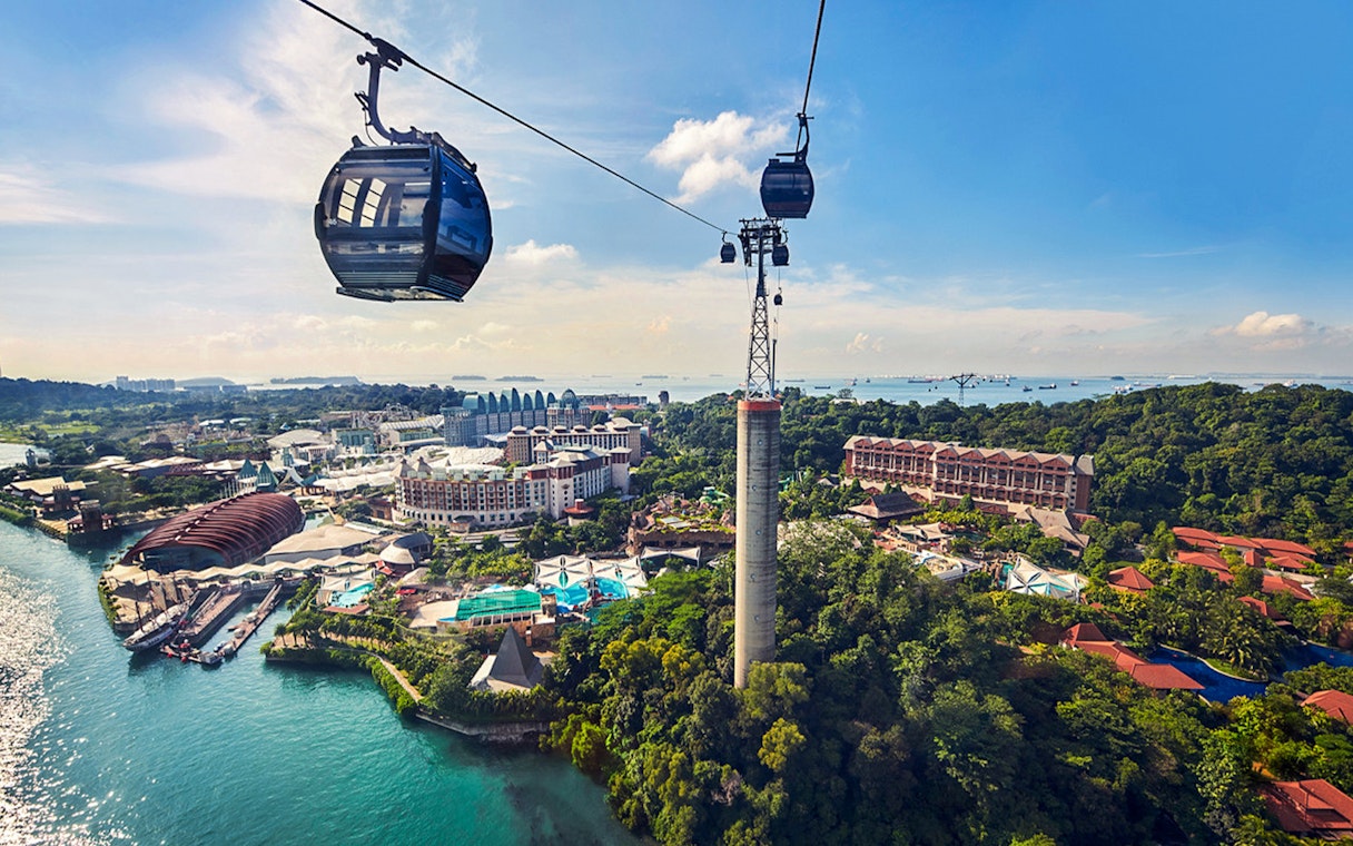 Cable car over Sentosa Island, Singapore, with view of attractions and coastline.