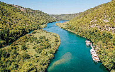 Boat on Krka River surrounded by lush greenery in Krka National Park, Croatia.