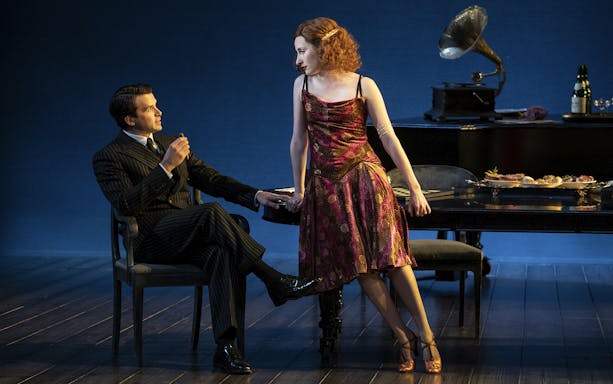 Man and woman in 1920s attire in a Leopoldstadt theater scene with gramophone and dining table.