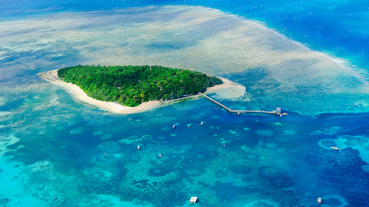 Aerial view of Green Island surrounded by coral reefs in the Great Barrier Reef, Australia.