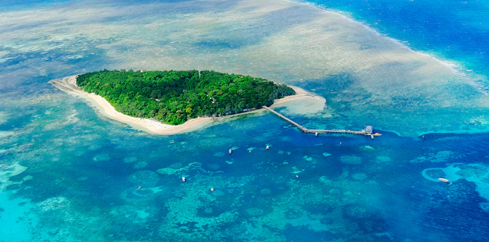 Aerial view of Green Island surrounded by coral reefs in the Great Barrier Reef, Australia.