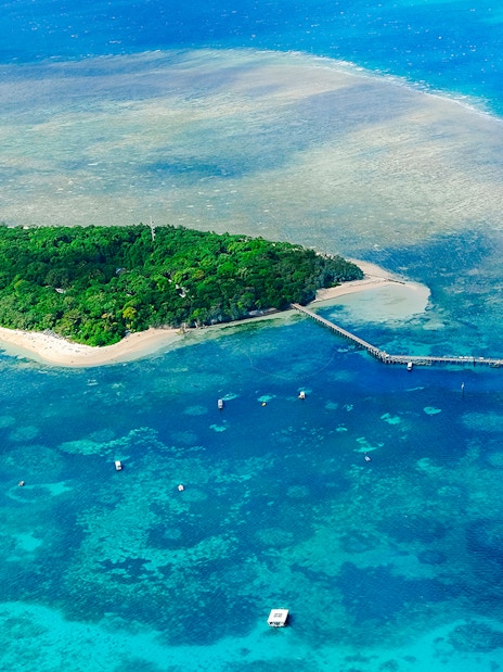 Aerial view of Green Island surrounded by coral reefs in the Great Barrier Reef, Australia.
