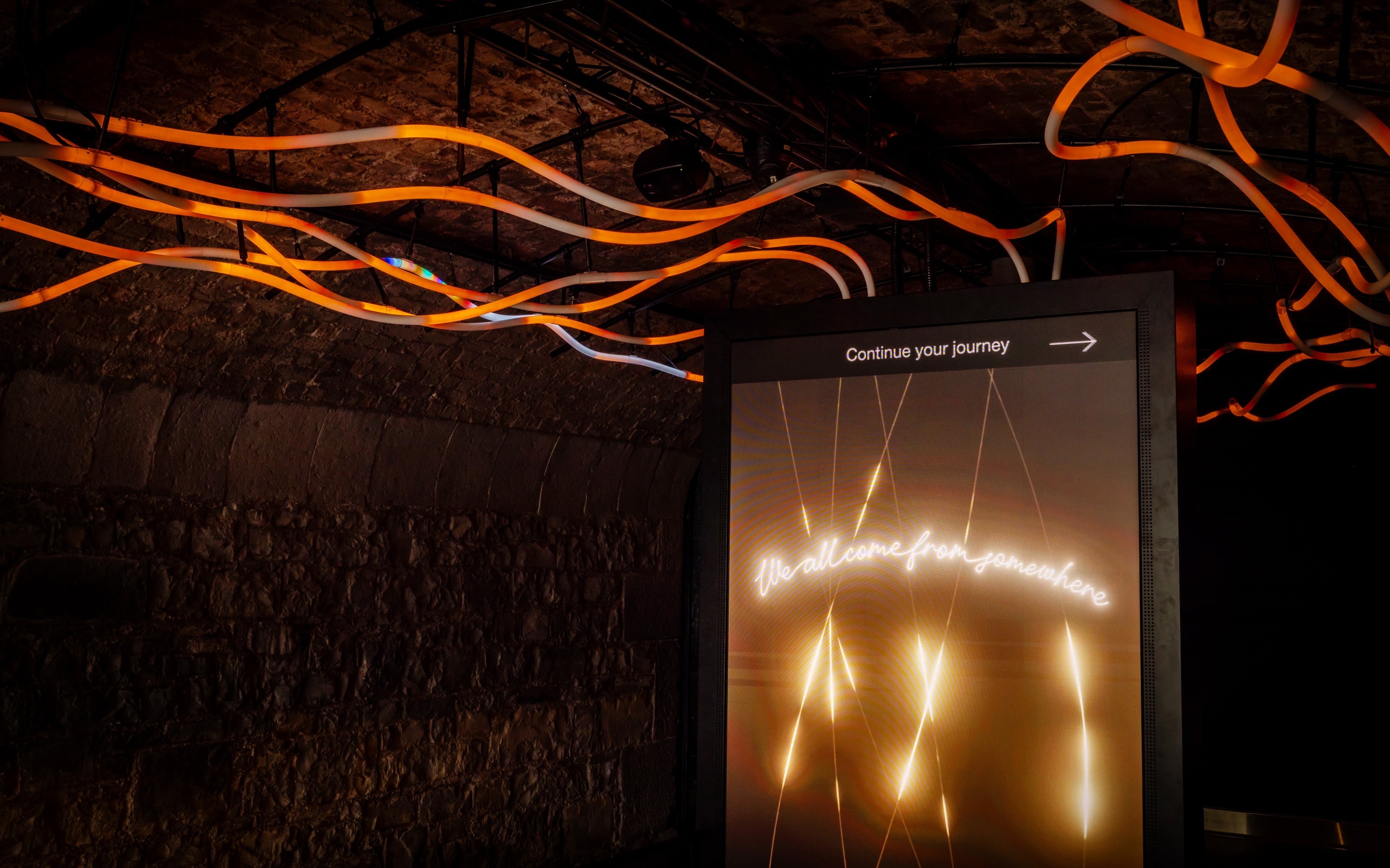Illuminated sign with "Continue your journey" in an underground exhibit at Epic Museum.