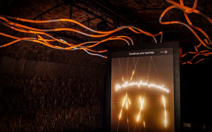 Illuminated sign with "Continue your journey" in an underground exhibit at Epic Museum.