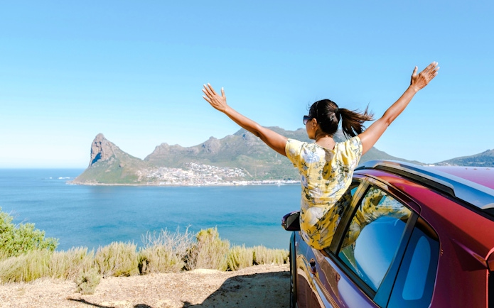 Person enjoying ocean view from Chapman's Peak Drive, Cape Peninsula, South Africa.