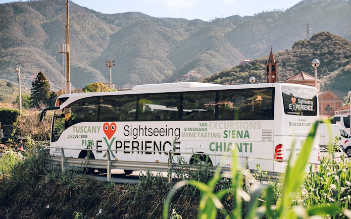 Sightseeing bus in Cinque Terre with mountain backdrop, part of Florence round-trip tour.