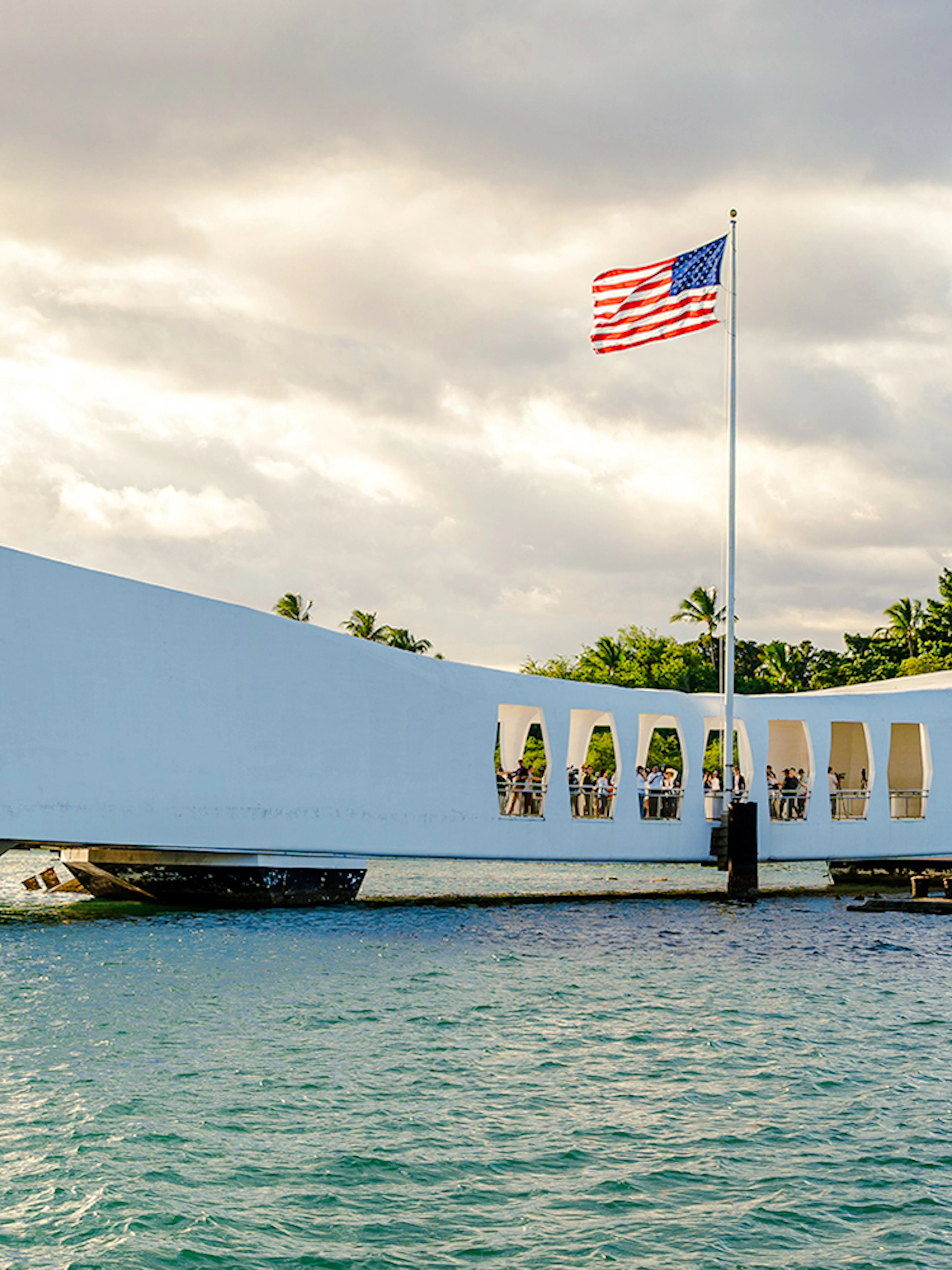 USS Arizona Memorial at Pearl Harbor with American flag flying.