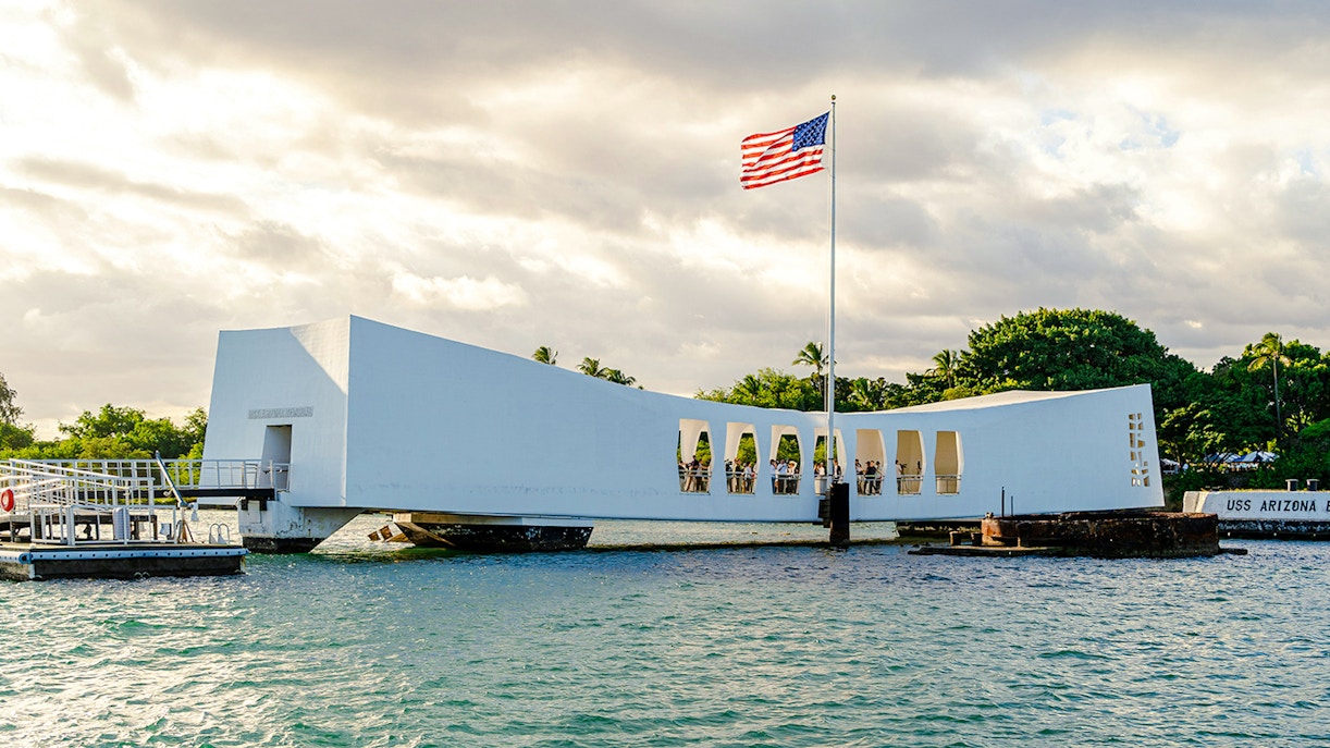 USS Arizona Memorial at Pearl Harbor with American flag flying.