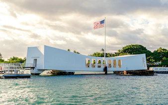 USS Arizona Memorial at Pearl Harbor with American flag flying.