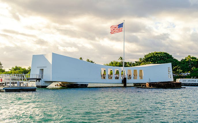 USS Arizona Memorial at Pearl Harbor with American flag flying.