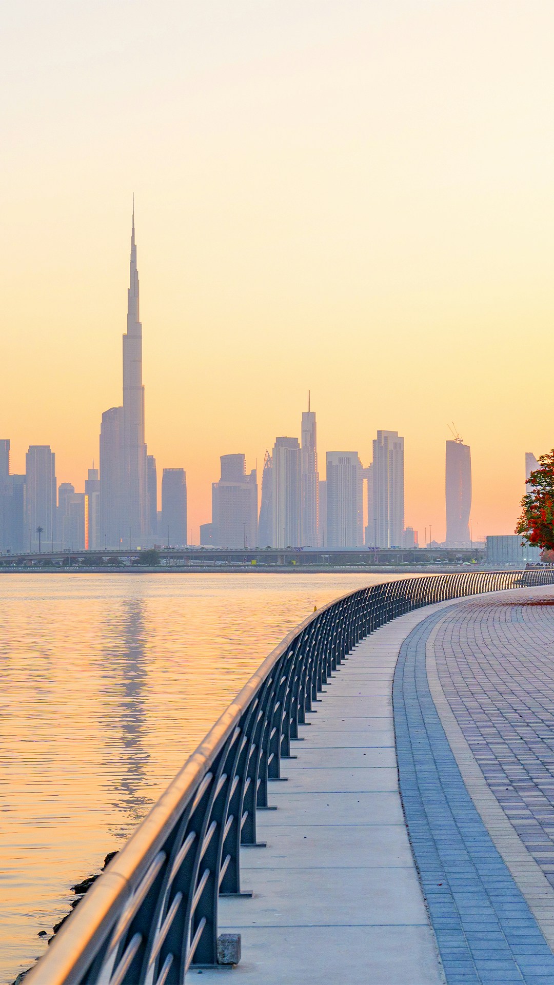 Dubai Water Canal Walk with downtown skyline at sunset.