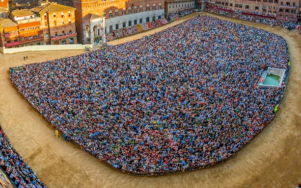 Crowd gathered in Siena's Piazza del Campo for the Palio horse race event.