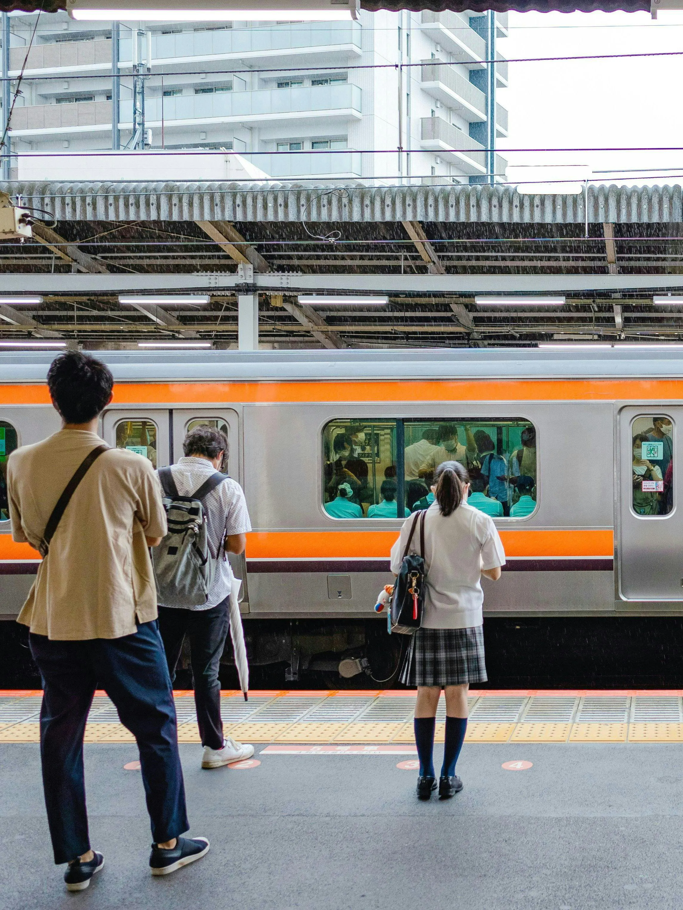 People waiting on a platform for a train at a Japanese station.