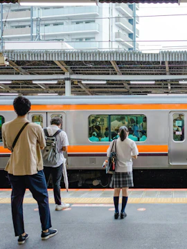 People waiting on a platform for a train at a Japanese station.