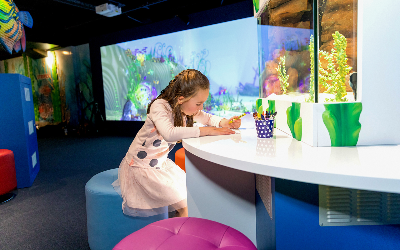 Child drawing at SEA LIFE Kelly Tarlton's Aquarium interactive area.