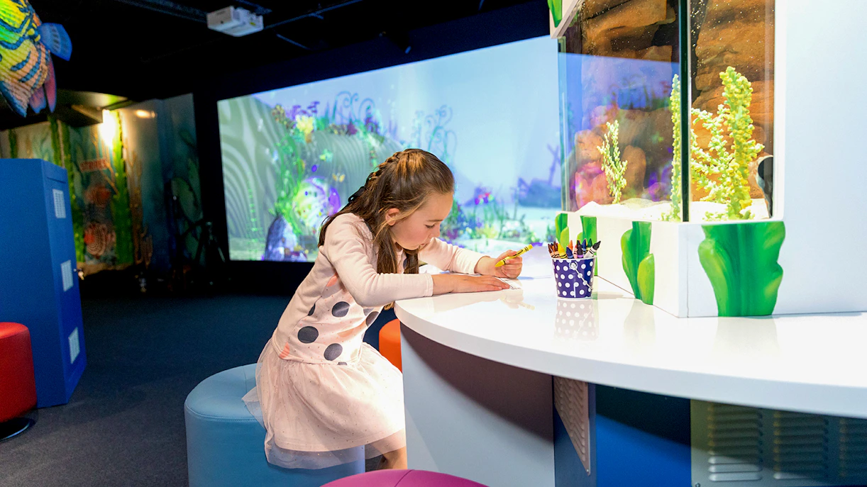 Child drawing at SEA LIFE Kelly Tarlton's Aquarium interactive area.