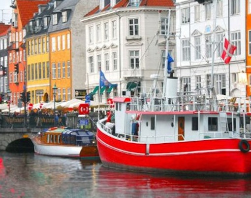 Colorful houses and a red boat in Nyhavn, Copenhagen canal cruise view.