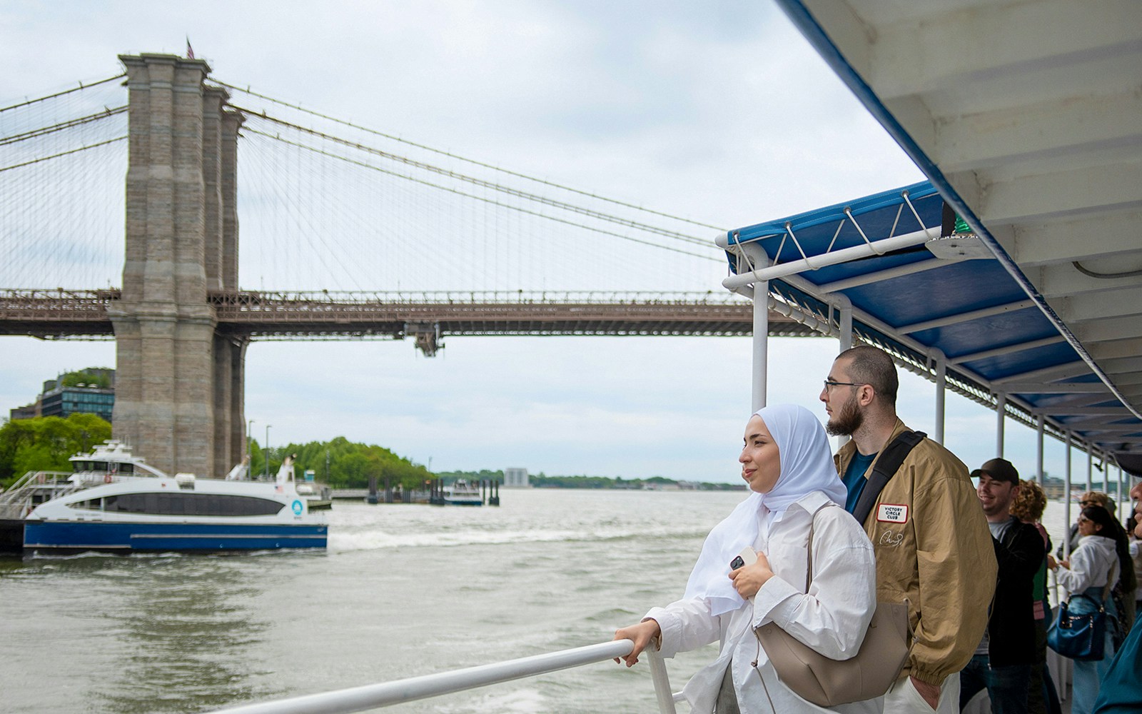 Couple enjoying a cruise near Brooklyn Bridge in New York City.