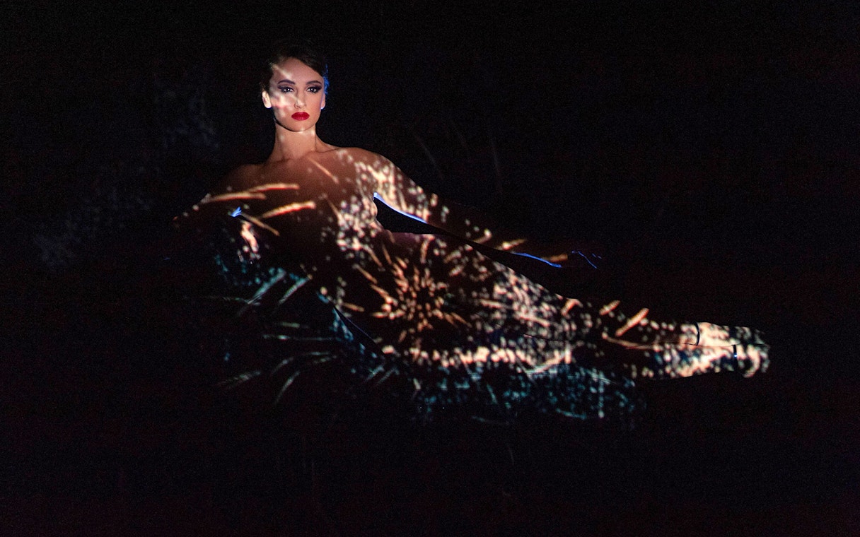 Performer at Crazy Horse Show with light projections, Paris.