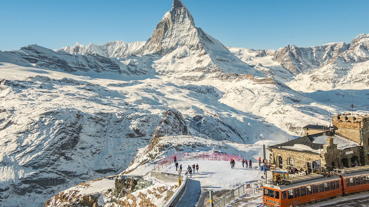 Matterhorn mountain view in Zermatt, Switzerland with snow-covered peaks and clear blue sky.